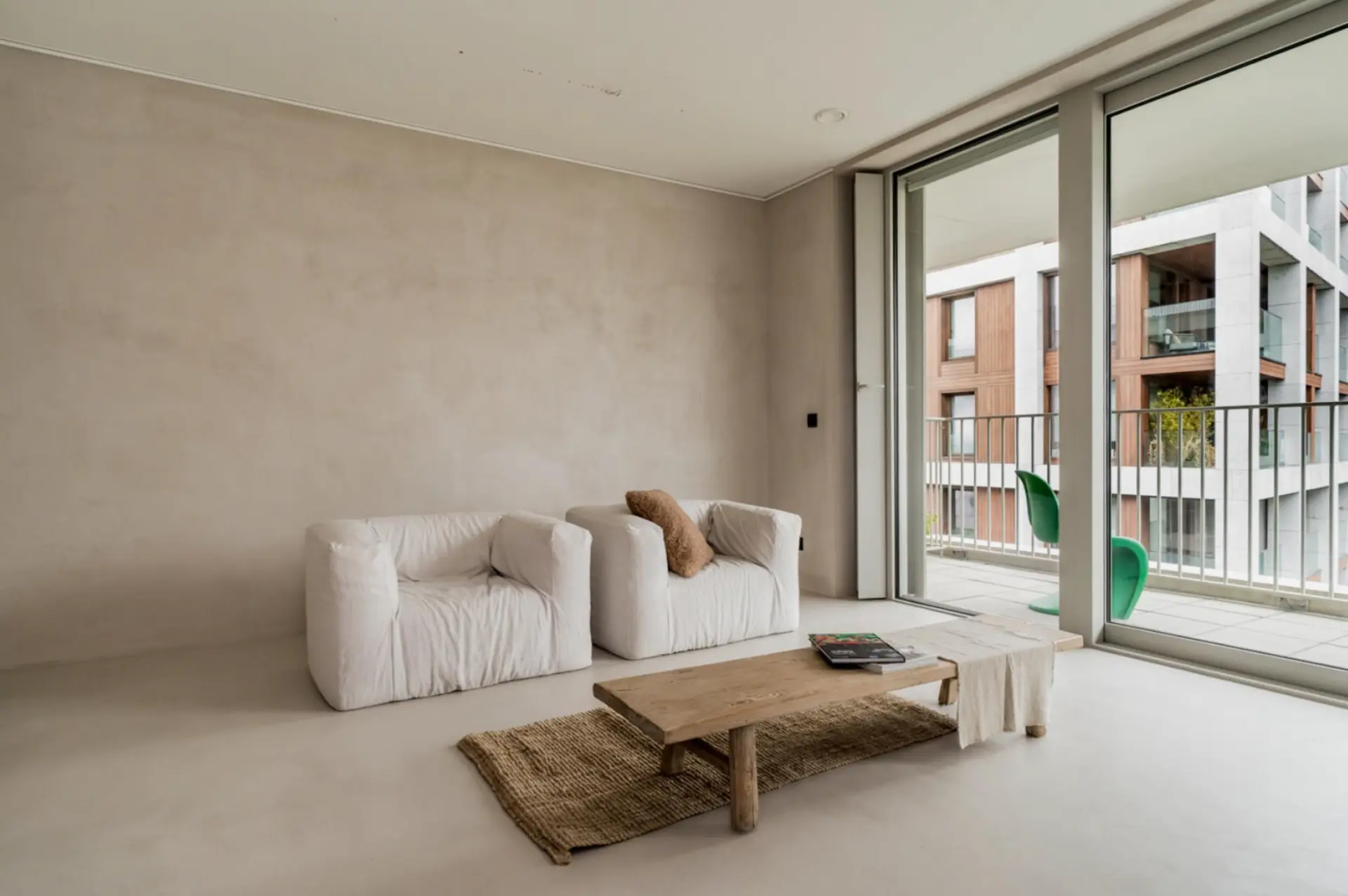 Living room with a textured beige microcement wall and seamless flooring